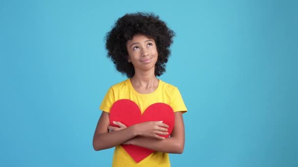 Álmodozó gyerek ölelés piros kártya szív romantikus ajándék elszigetelt kék szín háttér — Stock videók