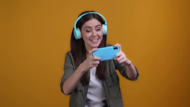 Lady utilizzare auricolare vincere dispositivo videogame isolato colore vibrante sfondo — Video Stock