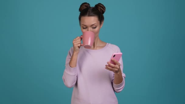 女性ブロガードリンクマグカップ飲料使用アプリデバイス孤立輝きの色背景 — ストック動画