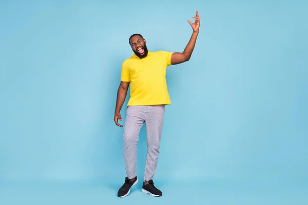 Fotografie funky legrační tmavé kůže muž nosit žluté tričko tanec křičí izolované modré barvy pozadí — Stock fotografie