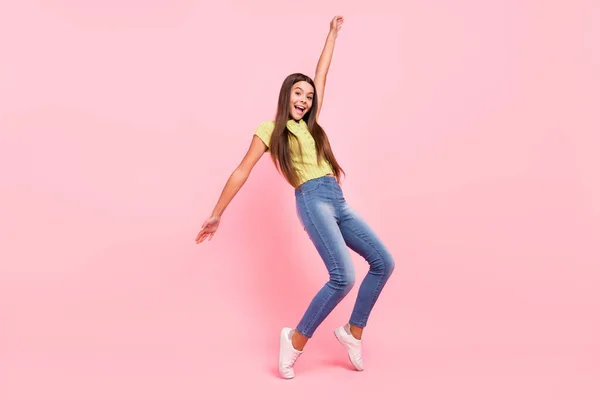 Foto de señora positiva danza divertido concepto de entretenimiento desgaste verde top jeans zapatillas aisladas de color rosa fondo —  Fotos de Stock