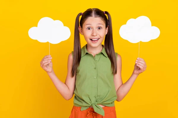 Foto de funky impresionado estudiante niña usar camisa verde sonriendo levantando dos burbujas de la mente espacio vacío aislado color amarillo fondo —  Fotos de Stock
