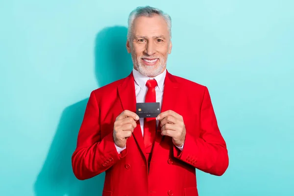 有魅力的退休人员身穿红色三件，显示信用卡孤立的茶色背景的照片 — 图库照片