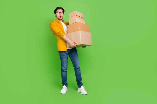 Foto de tamaño completo de los jóvenes sorprendidos hombres sostienen cajas pesadas moviendo nuevo hogar aislado en el fondo de color verde — Foto de Stock