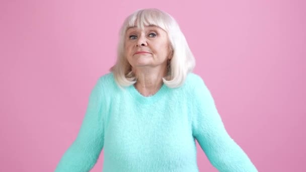 Anciana hombros encogiéndose de hombros no saben decisión aislado pastel color fondo — Vídeo de stock