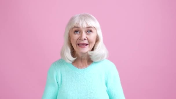 Oude dame verslaafd voetbal fan vuist omhoog geïsoleerde pastel kleur achtergrond — Stockvideo