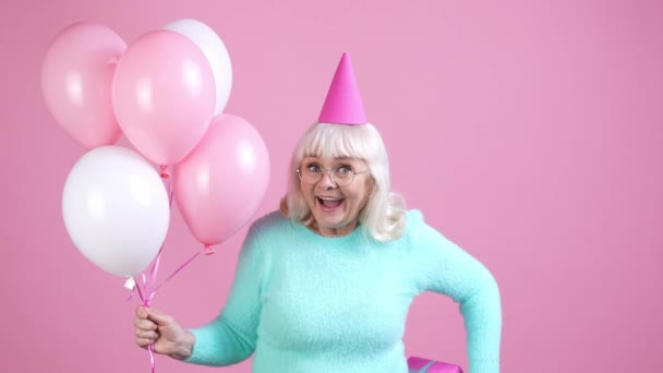 Lindo dulce abuelita dar paquete aire bolas aislado pastel color fondo — Vídeo de stock