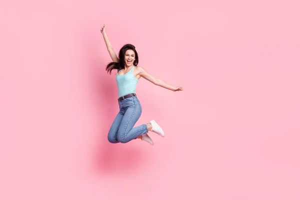 Full body profil fotografie cool milennial dáma skok nosit modré top džíny izolované na růžové barevné pozadí — Stock fotografie