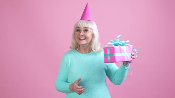 Abuela señora agitar paquete saludos aislado pastel color fondo — Vídeos de Stock