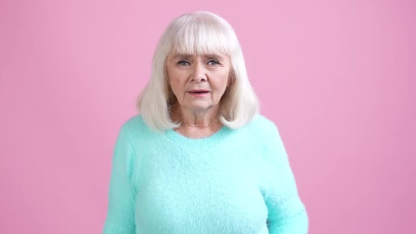 Senior dama impresionado rumor regalo aislado pastel color fondo — Vídeo de stock