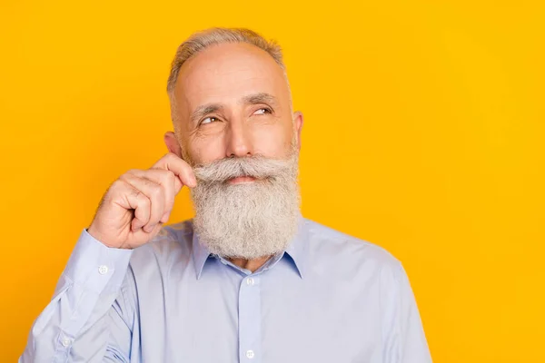 Foto de hombre viejo barba optimista mirada espacio vacío desgaste camisa azul aislado sobre fondo de color amarillo — Foto de Stock