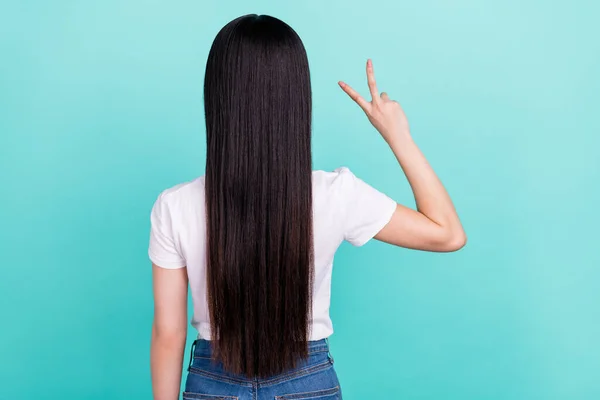 Back rear view photo of young asian girl anonym long hair treatment show peace v-sign isolated over turquoise color background