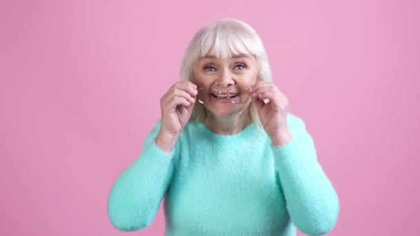 Стара леді виглядає неймовірно подарункові новини ізольовано пастельний кольоровий фон — стокове відео