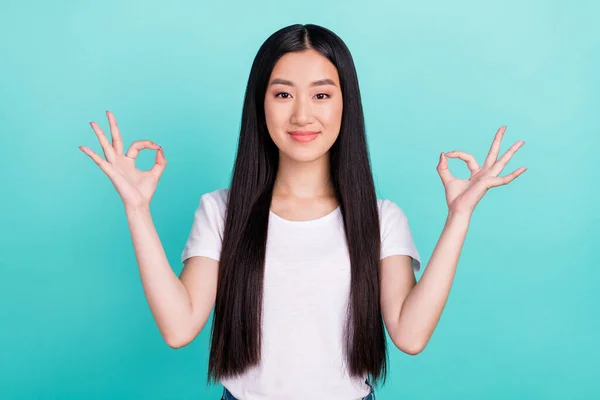 Foto de joven atractiva chica asiática feliz sonrisa positiva mostrar bien bien elegir signo aislado sobre fondo de color turquesa —  Fotos de Stock