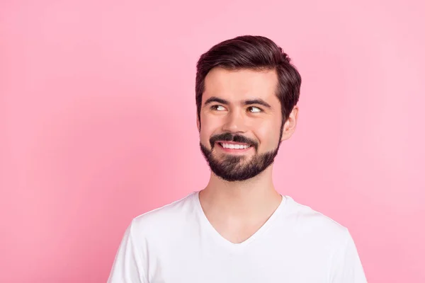 Foto von interessierten intelligenten nachdenklichen bärtigen Kerl suchen leeren Raum tragen weißes T-Shirt isoliert rosa Hintergrund — Stockfoto