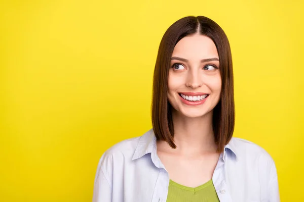 Kuva ihana brunette nuori nainen näyttää tyhjältä tilaa kulumista sininen paita eristetty keltainen väri tausta — kuvapankkivalokuva