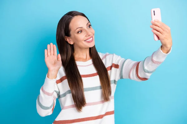 Foto de amigable linda señora blogger tomar teléfono selfie ola mano desgaste suéter a rayas aislado color azul fondo —  Fotos de Stock