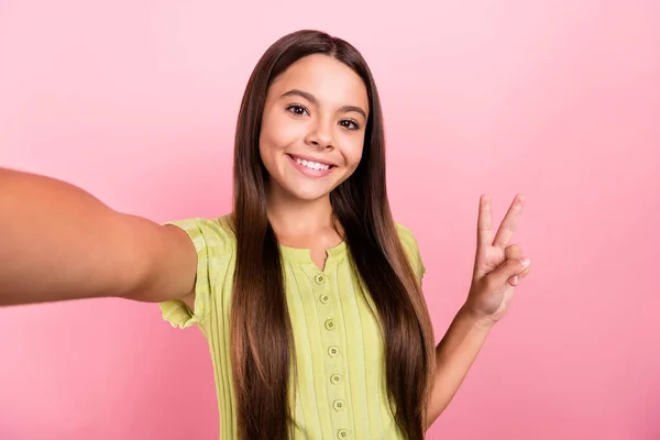 Foto van vrolijke vriendelijke kleine dame maken selfie show v-teken dragen groene top geïsoleerde roze kleur achtergrond — Stockfoto