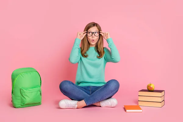 Foto von beeindruckt Schulmädchen gekleidet Krippenpullover Arme Brille liefert suchen leeren Raum isoliert rosa Farbe Hintergrund — Stockfoto