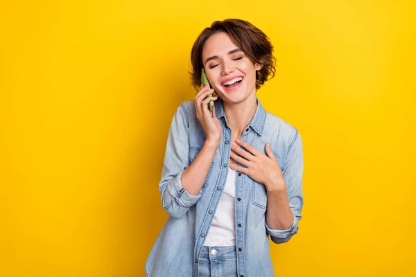 Fénykép a fiatal bájos lány értékelik kéz a mellkason beszélni mobil elszigetelt sárga szín háttér — Stock Fotó
