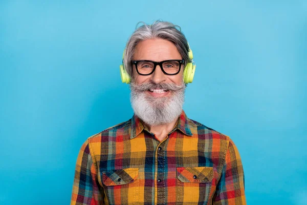 かなり魅力的な引退した男の写真は、演奏シャツの眼鏡を着用音楽を聞いて現代的なデバイス隔離された青の色の背景 — ストック写真