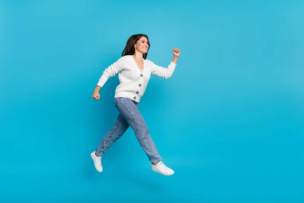 Foto de senhora bonita brilhante vestido cardigan branco saltando alto correndo rápido isolado fundo de cor azul — Fotografia de Stock