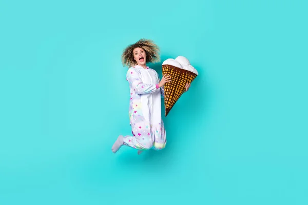 Full size photo of cool young curly hairdo lady jump with ice-cream wear kigurumi socks isolated on blue background — Stock Photo, Image