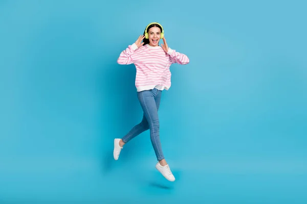 Full body photo of young lady active jump listen radio earphones meloman isolated over blue color background — Stock Photo, Image