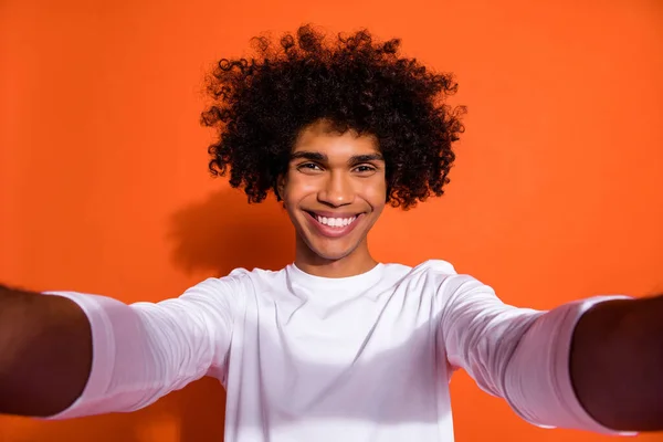 Foto van grappige charmante man gekleed wit shirt glimlachen spijkeren selfie geïsoleerde oranje kleur achtergrond — Stockfoto