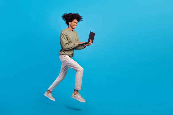 Full storlek profil sida foto av ung kille ser chatt typ laptop projekt rapport promenad hoppare isolerad över blå färg bakgrund — Stockfoto
