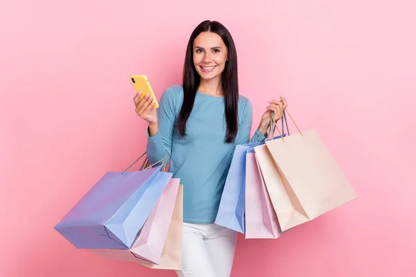 照片上漂亮可爱的女士穿着蓝色衬衫笑着抱着购物者输入现代设备孤立的粉色背景 — 图库照片