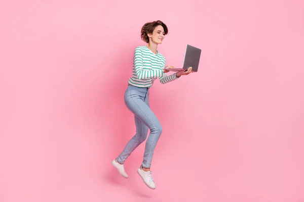 Full kropp profil foto av söta unga bob frisyr dam springa med bärbar dator slitage skjorta jeans sneakers isolerade på rosa bakgrund — Stockfoto