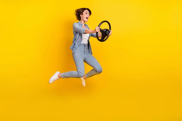 年轻女子跳高运动员的全身照片，看上去空荡荡的，与黄色背景隔离的宇宙飞船骑手 — 图库照片