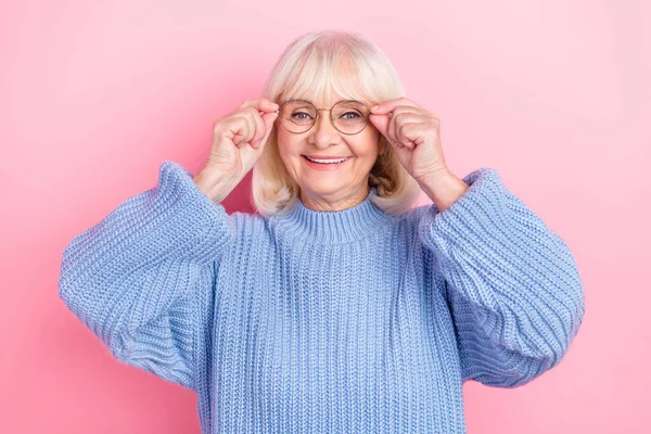 Fotografie veselá starší žena ruce dotek brýle oftalmologie izolované přes růžové barvy pozadí — Stock fotografie