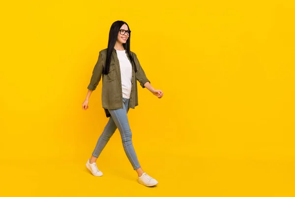 Full body photo of nice millennial lady go wear spectacles shirt jeans shoes isolated on yellow background — Stock Photo, Image