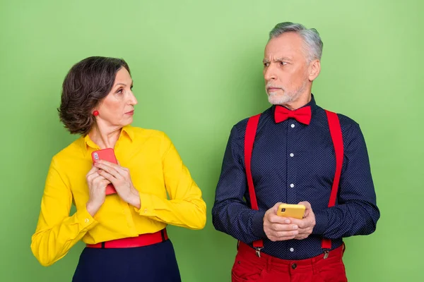 Retrato de dos personas de edad utilizan las redes sociales ocultan pantalla de teléfono cubierta aislado en fondo de color verde — Foto de Stock