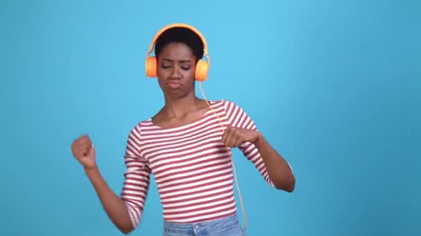 Божевільна леді хлопець слухати гарнітуру рок-танець ізольований синій колір фону — стокове відео