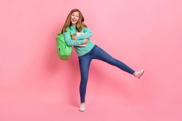 Foto de encantadora menina da escola vestido pulôver teal abraçando suprimentos isolado cor-de-rosa fundo — Fotografia de Stock