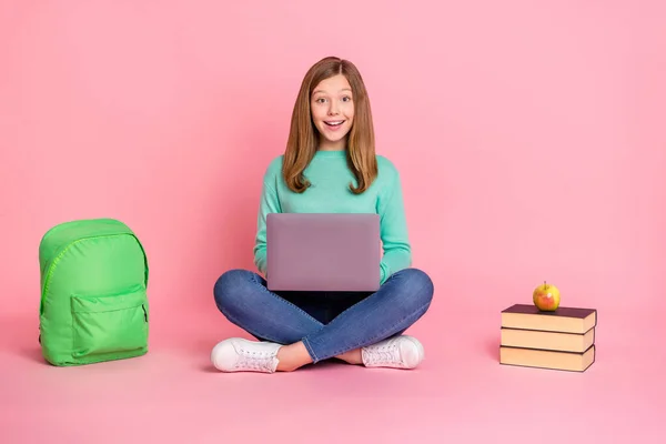 Fotografie docela vzrušený dívka nosit tyrkysový svetr držení školní zásoby zařízení izolované růžové barvy pozadí — Stock fotografie