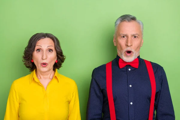 Foto de dos personas jubiladas impresionadas con la boca abierta mirando fijamente sin palabras cámara aislada en el fondo de color verde — Foto de Stock