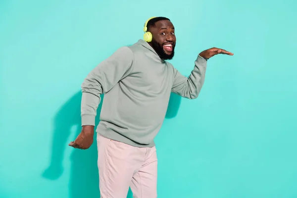 Porträtt av glad attraktiv kille dans lyssna enda pop har kul isolerad över levande teal turkos färg bakgrund — Stockfoto