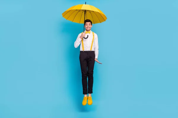 Full size portret van gekke vrolijke persoon houden paraplu regenachtig weer geïsoleerd op blauwe kleur achtergrond — Stockfoto