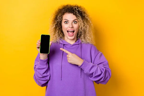 Fénykép a fiatal izgatott lány jelzi ujj mobil hirdetések javasoljuk dokumentum covid-19 izolált sárga színű háttér — Stock Fotó