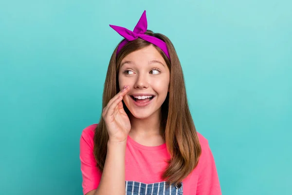 Foto de optimista peinado marrón niña pequeña dicen uso secreto banda de pelo rosa camiseta en general aislado sobre fondo de color verde azulado —  Fotos de Stock