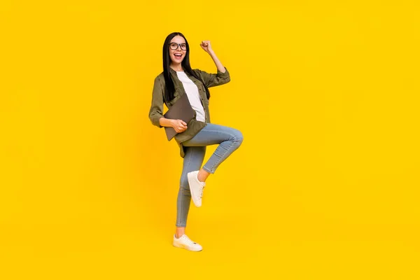 Pełny rozmiar zdjęcie ładna młoda dama trzymać laptop krzyczeć nosić okulary dżinsy buty izolowane na żółtym tle — Zdjęcie stockowe