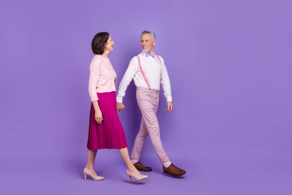Foto de perfil de longitud completa de dos elegantes parejas encantadoras caminando cogidas de la mano aisladas sobre fondo de color púrpura —  Fotos de Stock