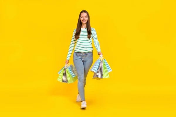 Πλήρης φωτογραφία του σώματος της νεαρής κυρίας κάνουν ψώνια με τα πόδια boutique έκπτωση απομονώνονται σε κίτρινο χρώμα φόντο — Φωτογραφία Αρχείου