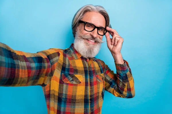 Photo of cheerful mature man make shoot video hand touch eyeglasses vacation isolated over blue color background — Stock Photo, Image