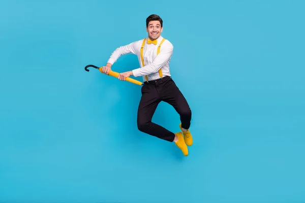 Volledige lengte foto van opgewonden tevreden man springen hold paraplu geïsoleerd op blauwe kleur achtergrond — Stockfoto