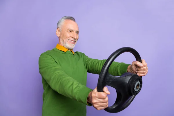 Photo of good mood retired man wear green sweater riding vehicle empty space isolated violet color background — Stock Photo, Image